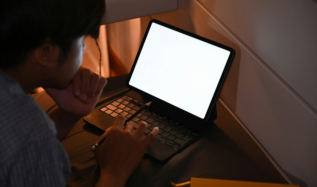 Junge in der Nacht vor einem PC