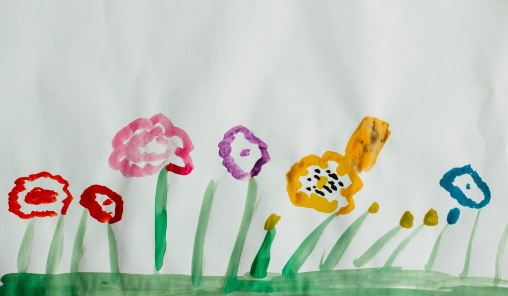 Kinderzeichnung mit Wasserfarben: Es sind blumen zu sehen.