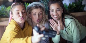 Drei junge Mädchen schauen mit "Kussmund" in eine Kamera.